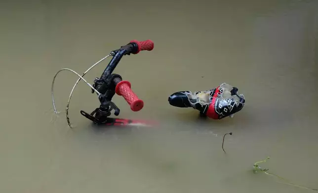 A bike is parked along floodwaters caused by heavy seasonal monsoon rains at Bagong Silangan village in Quezon city, Metro Manila, Philippines Monday, Aug. 10, 2026. (AP Photo/Aaron Favila) CORRECTION: Corrects typo in location to Silangan, instead of Silagan