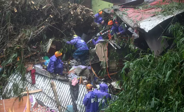 Rescuers conduct search and rescue operations for missing residents a day after several houses were buried from a landslide due to heavy monsoon rains in Guisad Surong, Baguio City, northern Philippines, Monday, Aug. 10, 2026. (AP Photo/Harley Palangchao)