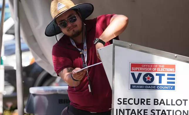 An election worker places a vote-by-mail ballot into a secure bin at the Miami-Dade County Supervisor of Elections Office during the Florida primary election in Doral, Fla., Tuesday, Aug. 18, 2026. (AP Photo/Lynne Sladky)
