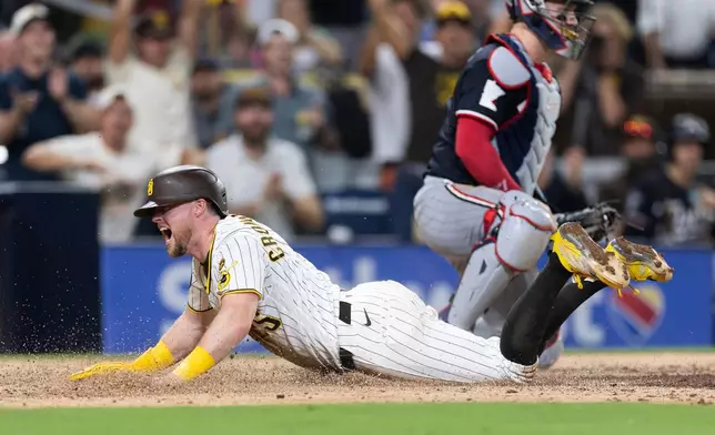 San Diego Padres' Jake Cronenworth, left, scores on an error by Minnesota Twins third baseman Brooks Lee (not shown) in the seventh inning of a baseball game Saturday, Aug. 22, 2026, in San Diego. (AP Photo/Karl Anderson)