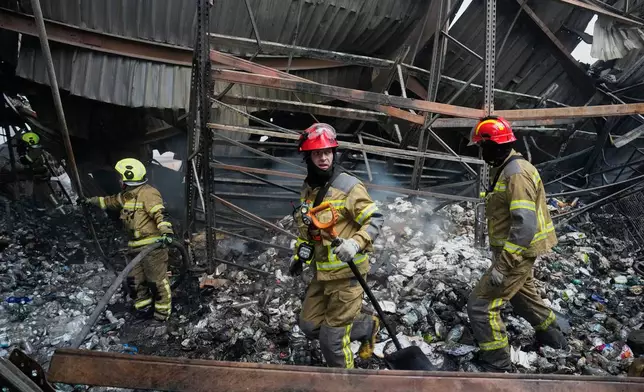 Firefighters put out a fire after Russian missiles hit a food warehouse near Kyiv, Ukraine, Wednesday, Aug. 5, 2026. (AP Photo/Efrem Lukatsky)