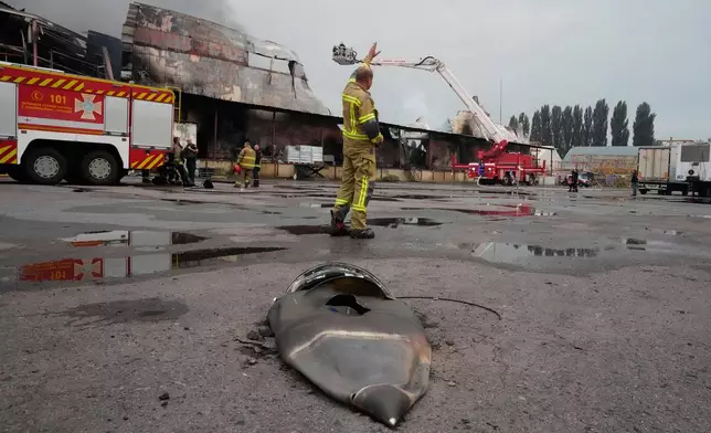 A firefighter reacts near a fragment of a Russian missile after air strikes at a food warehouse near Kyiv, Ukraine, Wednesday, Aug. 5, 2026. (AP Photo/Efrem Lukatsky)