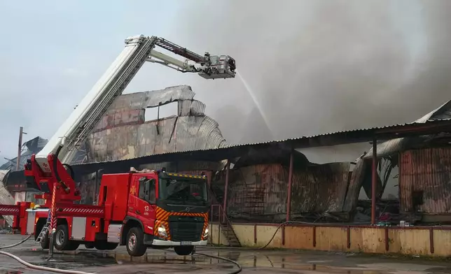 Firefighters put out a fire after Russian missiles hit a food warehouse near Kyiv, Ukraine, Wednesday, Aug. 5, 2026. (AP Photo/Efrem Lukatsky)