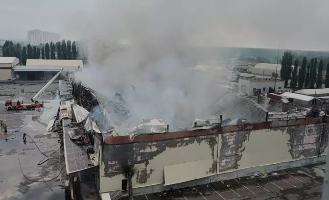 Firefighters put out a fire after Russian missiles hit a food warehouse near Kyiv, Ukraine, Wednesday, Aug. 5, 2026. (AP Photo/Efrem Lukatsky)