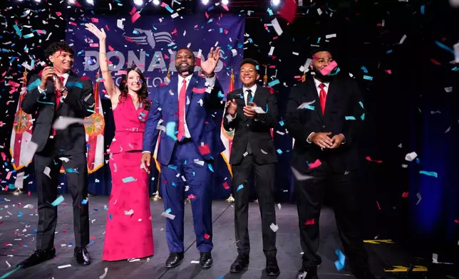 Florida Republican gubernatorial candidate Byron Donalds, center, waves next to his wife Erika, while standing on stage with their children Darin, left, Damon, second from left, and Mason during at a primary election party Tuesday, Aug. 18, 2026, in Orlando, Fla. (AP Photo/John Raoux)