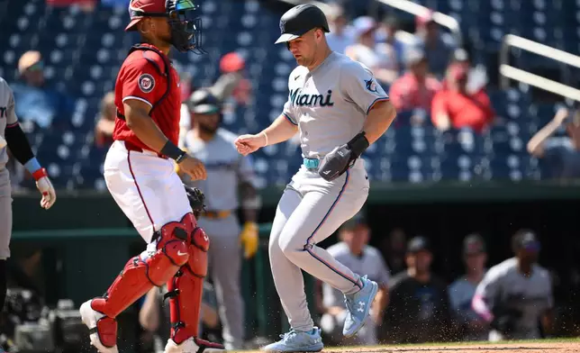 Miami Marlins' Jakob Marsee, right, steals home against Washington Nationals catcher Harry Ford, left, during the ninth inning of a baseball game, Sunday, Aug. 30, 2026, in Washington. (AP Photo/Nick Wass)