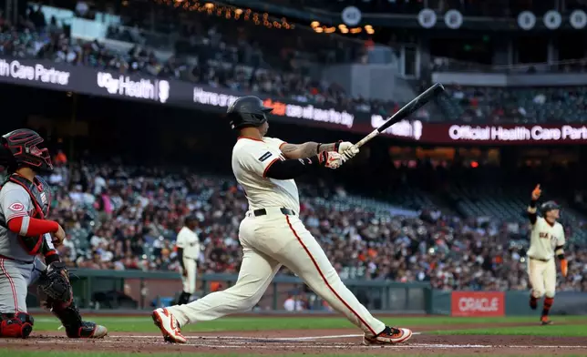 San Francisco Giants' Rafael Devers, right, watches his three-run home run in front of Cincinnati Reds catcher Jose Trevino, left, during the second inning of a baseball game in San Francisco, Monday, Aug. 24, 2026. (AP Photo/Jed Jacobsohn)