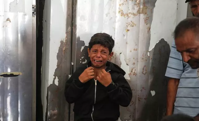 A Palestinian boy cries over the body of Hamouda al-Attar, who was killed by the Israeli army, during his funeral at al-Aqsa Hospital in Deir al-Balah, central Gaza Strip, Saturday, Aug. 29, 2026. (AP Photo/Abdel Kareem Hana)