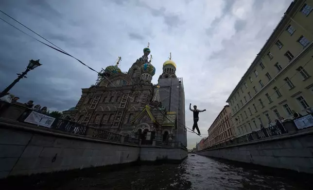 Tightrope walker Maxim Kagin performs over Griboyedov Channel next to the Saviour of Spilled Blood Cathedral in St. Petersburg, Russia, Friday, Aug. 28, 2026. (AP Photo/Dmitri Lovetsky)