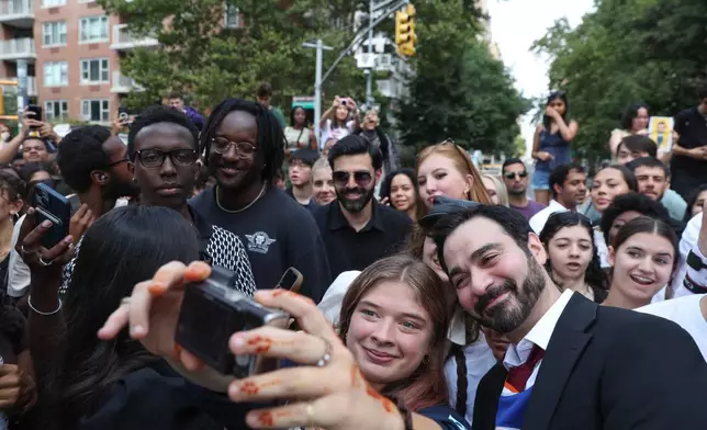 Amadeo Fusca, winner of the Mayor Zohran Mamdani look-alike contest, takes selfies with the crowd, Sunday, Aug. 30, 2026, in New York. (AP Photo/Heather Khalifa)