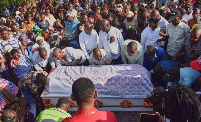 Mourners gather as the casket of 29 years old Penina Zawadi, who died from complications while giving birth, is lowered into her grave during her funeral in Kilifi County, Kenya, Saturday, July 18, 2026. (AP Photo/Brian Wachira)
