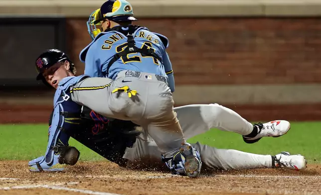 Milwaukee Brewers catcher William Contreras (24) tags out New York Mets' Brett Baty trying to score a run during the sixth inning of a baseball game on Tuesday, Aug. 25, 2026, in New York. (AP Photo/Adam Hunger)
