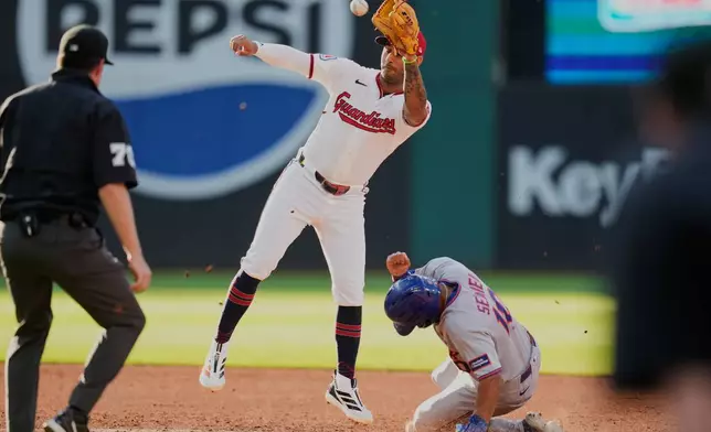 New York Mets' Marcus Semien, right, steals second base as Cleveland Guardians shortstop Brayan Rocchio, center, takes the throw in the second inning of a baseball game in Cleveland, Tuesday, Aug. 4, 2026. (AP Photo/Sue Ogrocki)