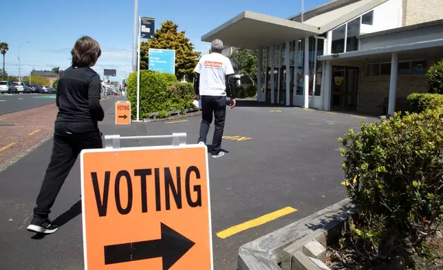 FILE - A couple arrive to vote at a polling station in Auckland, New Zealand, Oct. 17, 2020. (AP Photo/Mark Baker, File)