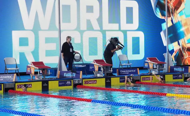 Kate Douglass, of the United States, right, gets out of the pool after winning the women's 50 meters freestyle final with a new world record at the Pan Pacific Swimming Championships Saturday, Aug. 15, 2026 in Irvine, Calif. (AP Photo/Gregory Bull)
