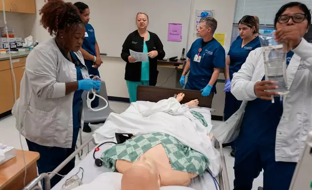 Instructor Renee McFatridge, center back, directs nursing students in the simulation lab at Forsyth Technical Community College in Winston-Salem, N.C., Thursday, Aug. 20, 2026. (AP Photo/Chuck Burton)