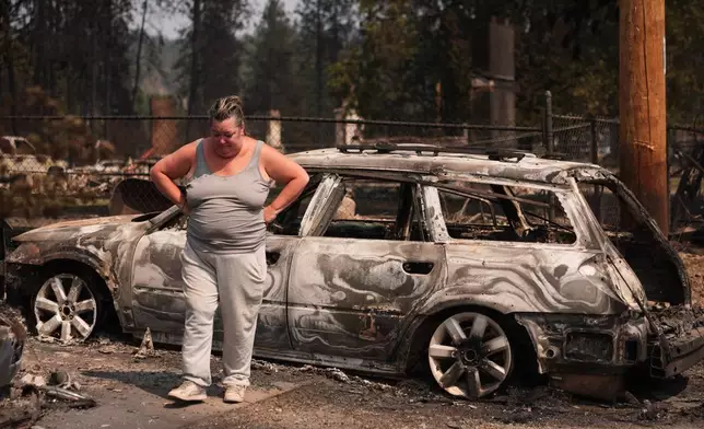 Michelle Angstrom reacts to her burned down home and property after a wildfire hit the northwest part of Spokane, Wash., Tuesday, Aug. 4, 2026. (AP Photo/Lindsey Wasson)