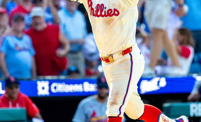 Philadelphia Phillies' Kyle Schwarber gestures while running to home plate after hitting the winning home run in the ninth inning of a baseball game against the St. Louis Cardinals, Sunday, Aug. 23, 2026, in Philadelphia. (AP Photo/Laurence Kesterson)
