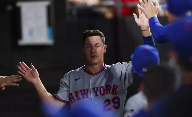 New York Mets' Jared Young (29) celebrates in the dugout after scoring during the fourth inning of a baseball game against the Chicago White Sox in Chicago, Friday, Aug. 21, 2026. (AP Photo/Jessie Alcheh)