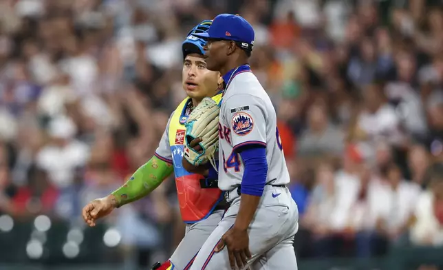 New York Mets pitcher Jefry Yan, right, and catcher Francisco Alvarez, left, interact while walking toward the mound during the ninth inning of a baseball game against the Chicago White Sox in Chicago, Friday, Aug. 21, 2026. (AP Photo/Jessie Alcheh)