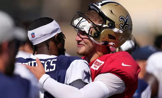 Dallas Cowboys cornerback Trikweze Bridges, left, greets New Orleans Saints quarterback Tyler Shough during an NFL football joint practice, Tuesday, Aug. 18, 2026, in Oxnard, Calif. (AP Photo/Mark J. Terrill)