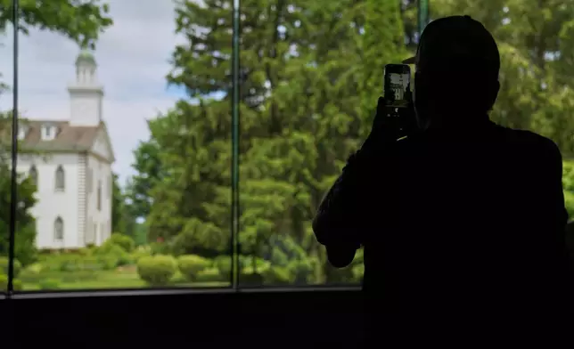 A visitor takes a photo of the Kirtland temple, a nearly two-century old sanctuary considered the first temple in the movement Joseph Smith founded, on Wednesday, June 15, 2026, in Kirtland, Ohio. (AP Photo/Jessie Wardarski)