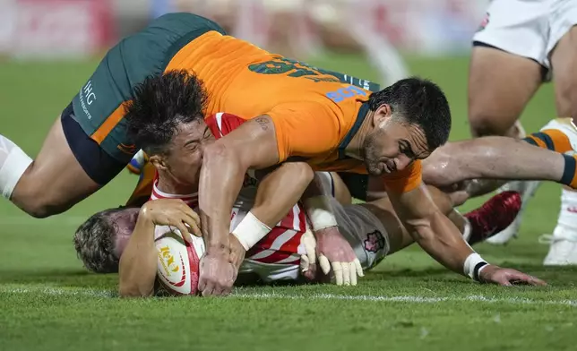 Japan's Ryunosuke Ito, bottom, makes a try as Australia's Tom Wright attempted to stop during the first half of their rugby match in Higashi Osaka, western Japan, Saturday, Aug. 8, 2026. (Yuki Sato/Kyodo News via AP)