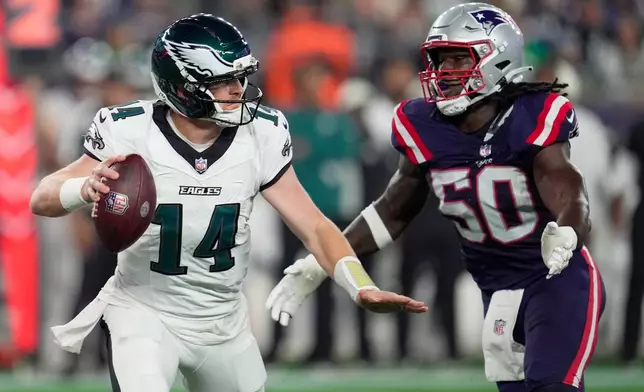 Philadelphia Eagles quarterback Andy Dalton (14) is pressured by New England Patriots linebacker Gabe Jacus during the first half of an NFL preseason football game, Saturday, Aug. 22, 2026, in Foxborough, Mass. (AP Photo/Robert F. Bukaty)