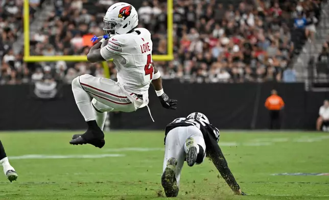 Arizona Cardinals running back Jeremiyah Love (4) spins away from Las Vegas Raiders cornerback Hezekiah Masses during the first half of a preseason NFL football game, Thursday, Aug. 13, 2026, in Las Vegas. (AP Photo/David Becker)