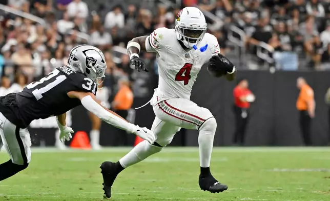Arizona Cardinals running back Jeremiyah Love (4) runs past Las Vegas Raiders safety Treydan Stukes (31) during the first half of a preseason NFL football game, Thursday, Aug. 13, 2026, in Las Vegas. (AP Photo/David Becker)