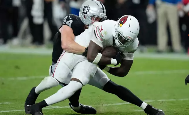 Arizona Cardinals running back Jeremiyah Love, right, runs with the ball as he is tackled by Las Vegas Raiders linebacker Tommy Eichenberg (44) during the first half of a preseason NFL football game, Thursday, Aug. 13, 2026, in Las Vegas. (AP Photo/John Locher)