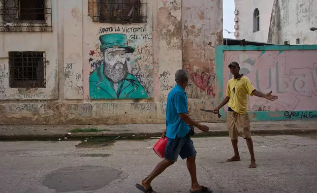 Men argue in front of a weathered mural of Fidel Castro in Havana, Cuba, Wednesday, Aug. 12, 2026. (AP Photo/Ramon Espinosa)