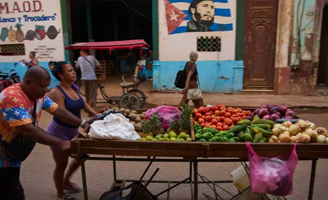 Street vendors push their cart of vegetables past a mural of Fidel Castro in Havana, Cuba, Wednesday, Aug. 12, 2026. (AP Photo/Ramon Espinosa)
