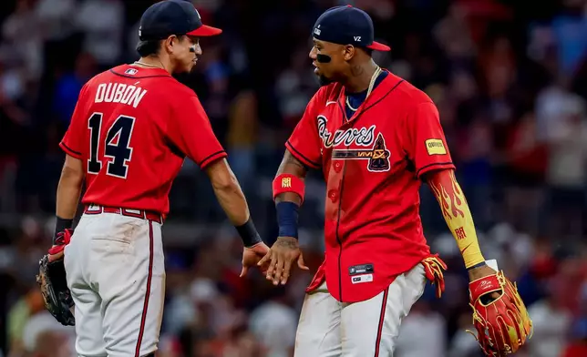 Atlanta Braves' Ronald Acuña Jr., right, celebrates with Mauricio Dubón (14) after their team defeated the Colorado Rockies in a baseball game, Friday, Aug. 28, 2026, in Atlanta. (AP Photo/Erik S. Lesser)