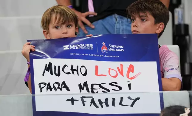 Fans hold a sign in support of Inter Miami forward Lionel Messi, who's father Jorge Messi passed away, before a Leagues Cup soccer match between Inter Miami and Monterrey, Saturday, Aug. 8, 2026, in Miami. (AP Photo/Lynne Sladky)