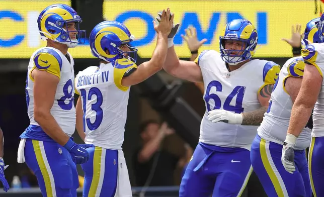 Los Angeles Rams quarterback Stetson Bennett (13) celebrates his rushing touchdown with teammates during the first half an NFL preseason football game against the New Orleans Saints Saturday, Aug. 22, 2026, in Inglewood, Calif. (AP Photo/Ryan Sun)