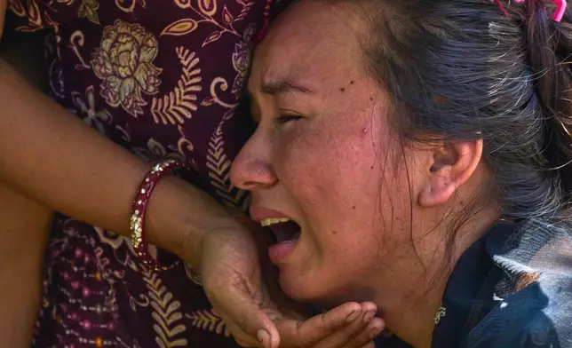 A girl cries as she waits for news of relatives missing after flash floods in Bidur, Nepal's Nuwakot district, Thursday, Aug. 27, 2026. (AP Photo/Niranjan Shrestha)