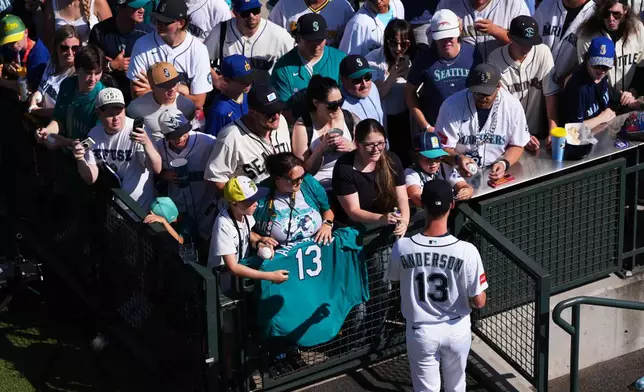 Seattle Mariners starting pitcher Kade Anderson signs autographs in the bullpen before making his major league debut against the Chicago Cubs in a baseball game, Saturday, Aug. 22, 2026, in Seattle. (AP Photo/Lindsey Wasson)