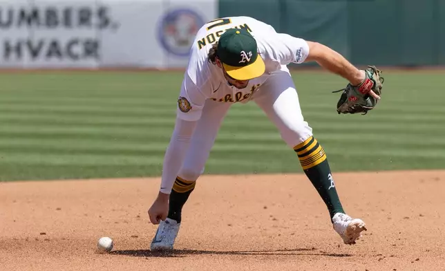 Athletics shortstop Jacob Wilson attempts to field a ball during the fourth inning of a baseball game against the Texas Rangers, Sunday, Aug. 16, 2026, in West Sacramento, Calif. (AP Photo/Sara Nevis)