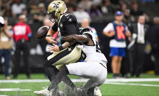 New Orleans Saints quarterback Spencer Rattler fumbles as he is sacked by Jacksonville Jaguars linebacker Yasir Abdullah, right, during the first half of an NFL preseason football game Saturday, Aug. 15, 2026, in New Orleans. (AP Photo/Ella Hall)