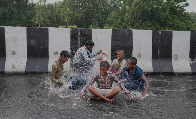 Children play in the rain on the highway during monsoon showers on the outskirts of Raebareli District, in the northern Indian state of Uttar Pradesh, Sunday, Aug. 2, 2026. (AP Photo/Rajesh Kumar Singh)