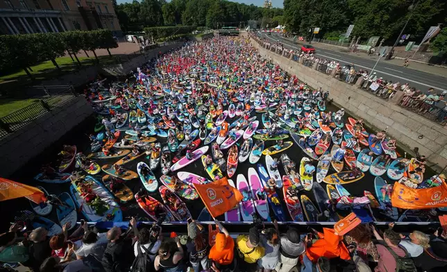 People steer their stand-up paddle (SUP) boards along the Moyka River at the annual costumed 'Fontanka' SUP-boards festival in St. Petersburg, Russia, Saturday, Aug. 1, 2026. (AP Photo/Dmitri Lovetsky)