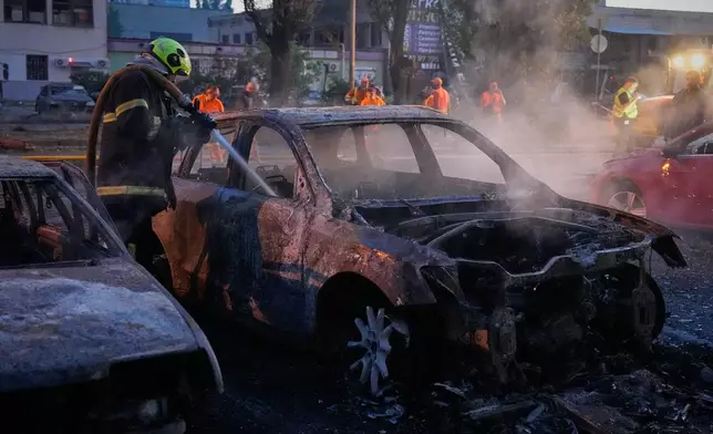 Emergency services personnel work to extinguish a fire following Russian missile attacks in Kyiv, Ukraine, Saturday, Aug. 1, 2026. (AP Photo/Efrem Lukatsky)