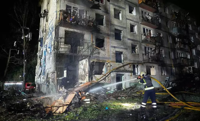 Emergency services personnel work to extinguish a fire following Russian missile attacks in Kyiv, Ukraine, Saturday, Aug. 1, 2026. (AP Photo/Efrem Lukatsky)