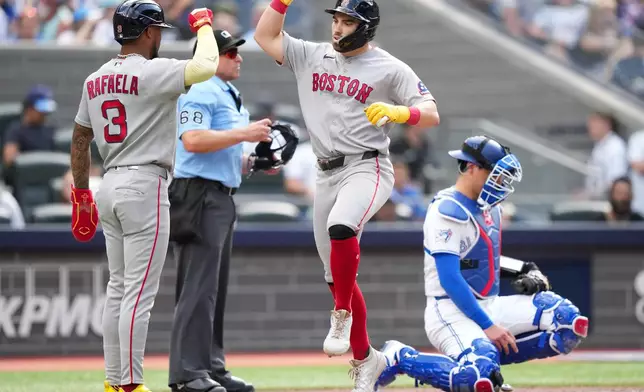 Boston Red Sox third baseman Caleb Durbin (5) celebrates his grand slam with teammate Ceddanne Rafaela (3) as Toronto Blue Jays catcher Brandon Valenzuela (59) looks on during the eighth inning of a baseball game in Toronto, Thursday, Aug. 13, 2026. (Nathan Denette/The Canadian Press via AP)