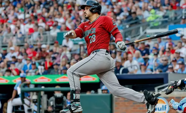 Arizona Diamondbacks third baseman Nolan Arenado (28) follows through on an RBI grounder against the Atlanta Braves during the second inning of a baseball game, Saturday, August 15, 2026, in Atlanta. (AP Photo/Erik S. Lesser)