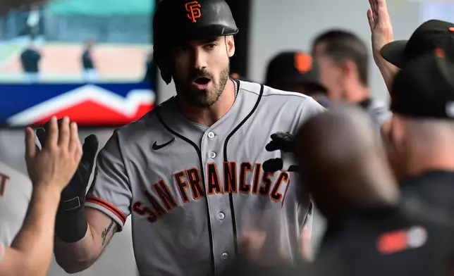San Francisco Giants' Bryce Eldridge is congratulated in the dugout after hitting a solo home run off Cleveland Guardians starting pitcher Foster Griffin during the second inning of a baseball game, Tuesday, Aug. 18, 2026, in Cleveland. (AP Photo/David Dermer)