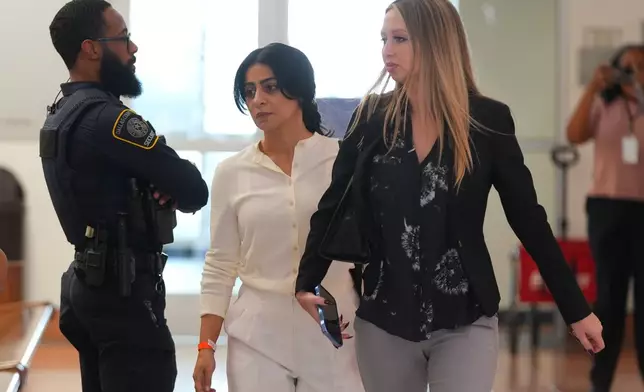 Nausheen Gilkar, center, walks in a hallway at family court in Dallas, Tuesday, Aug. 25, 2026. (AP Photo/LM Otero)