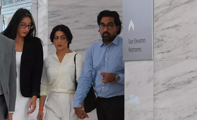 Omar Ahmed, right, and his wife Nausheen Gilkar, center, arrive for a court hearing in Dallas, Tuesday, Aug. 25, 2026. (AP Photo/LM Otero)