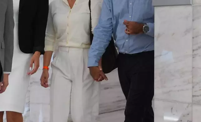 Omar Ahmed, right, and his wife Nausheen Gilkar, center, arrive for a court hearing in Dallas, Tuesday, Aug. 25, 2026. (AP Photo/LM Otero)